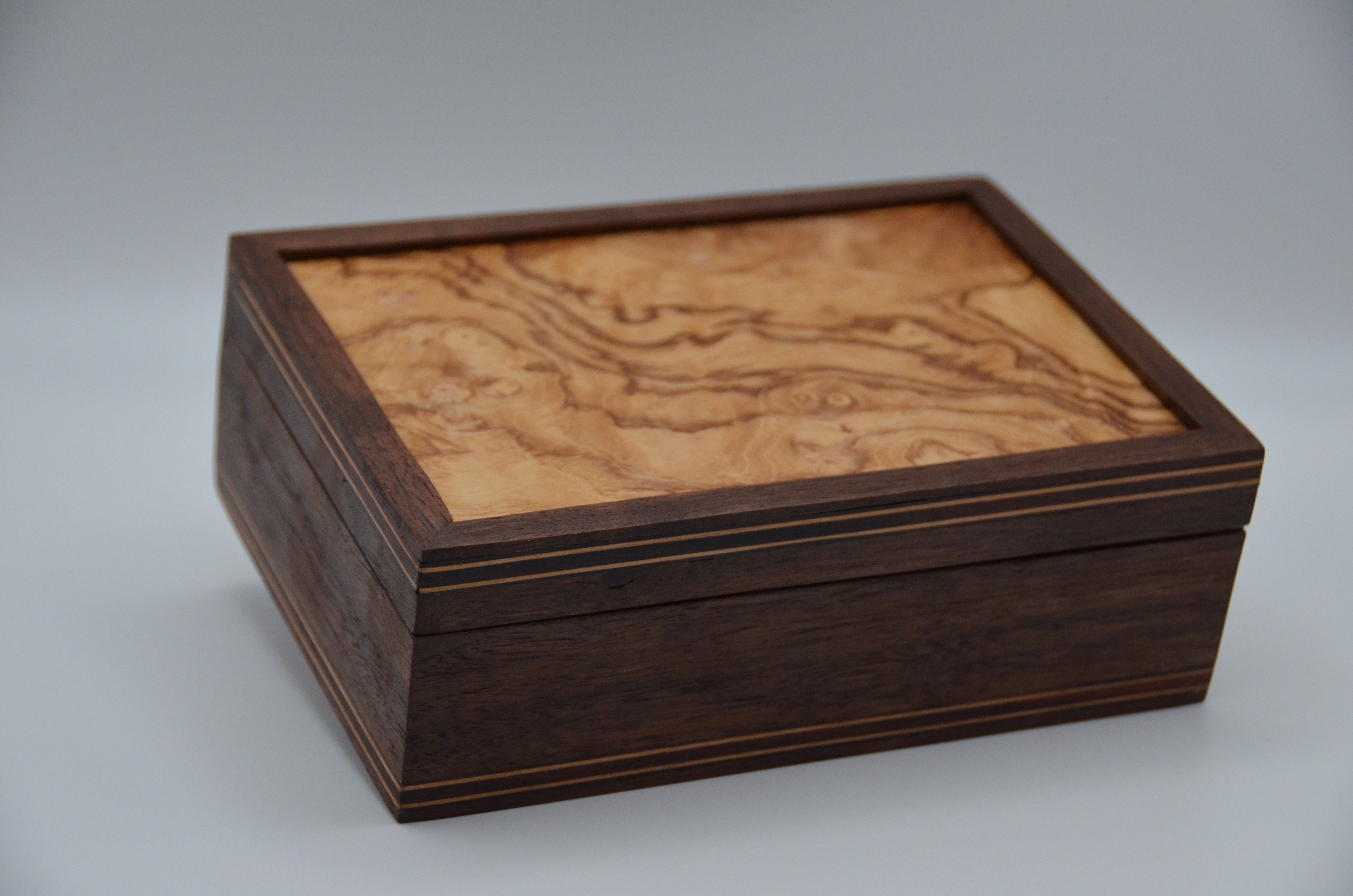 Handmade wooden box with emphasis on the lid, corner, and wood grain.