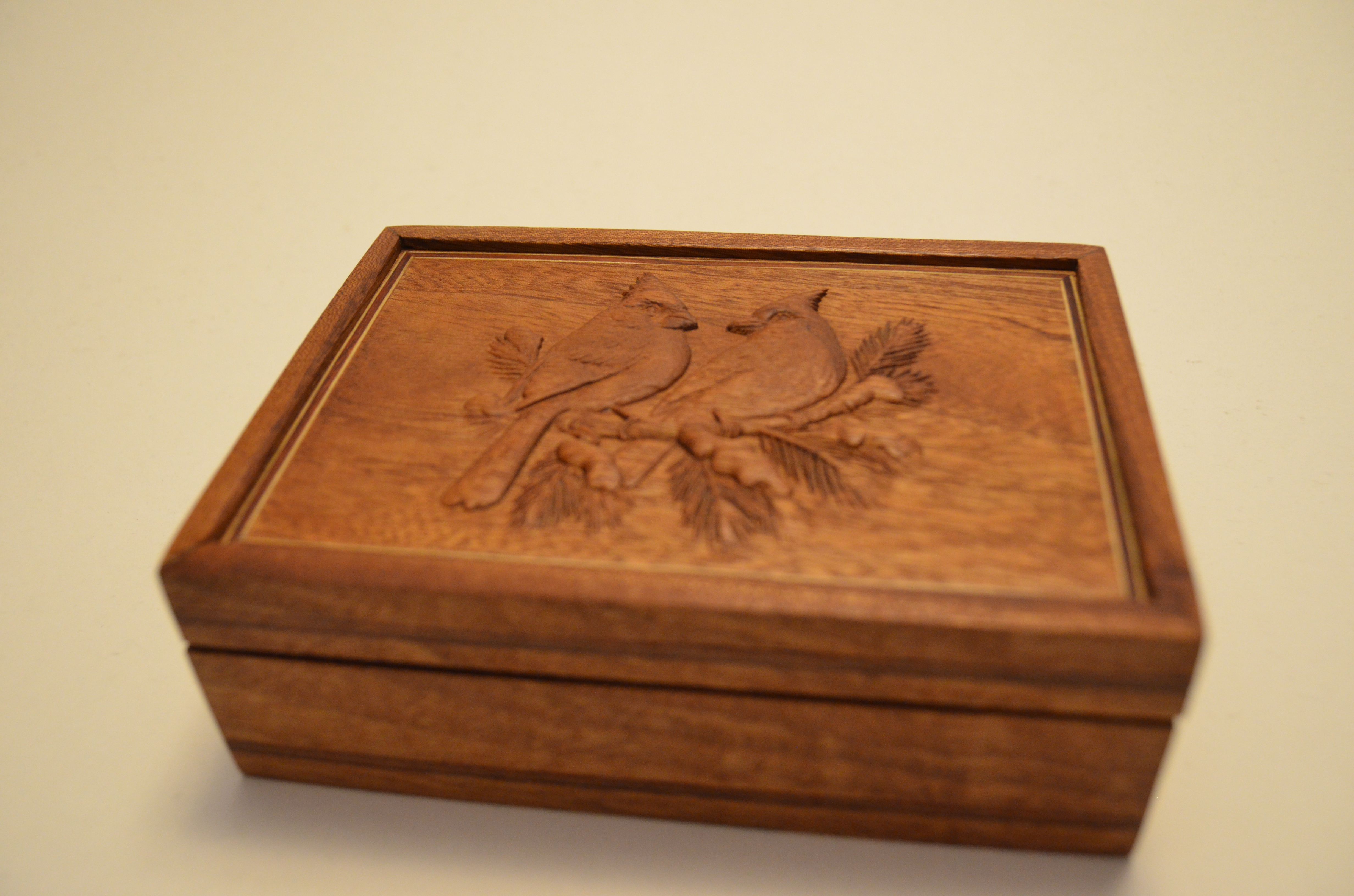 Close studio view of a wooden box showing surface figure and joinery detail.